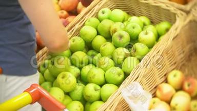 年轻女子在<strong>水果蔬菜超市</strong>市场选择苹果。 4k